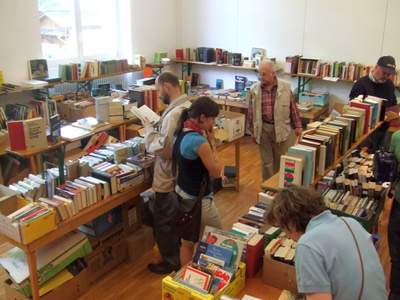 Menschen im Innenraum an Büchertischen